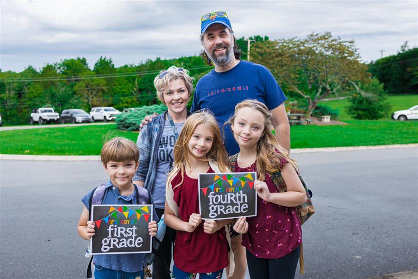 A family smiles on the first day of school